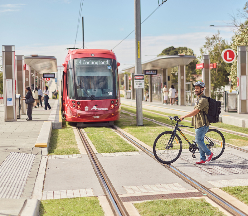 Passengers and cyclists boarding a modern light rail train