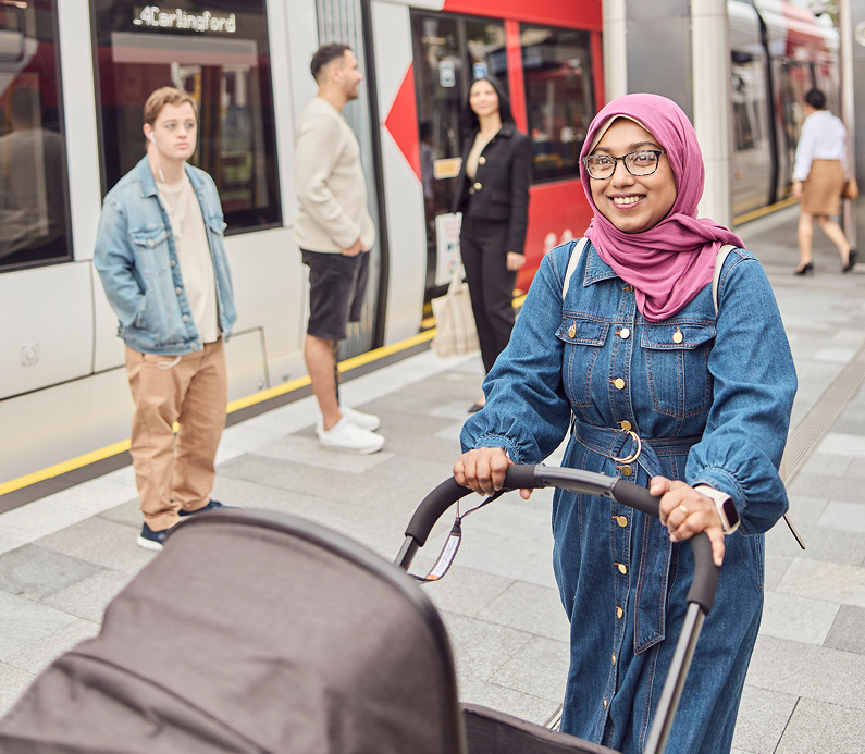People from diverse backgrounds waiting at a light rail station