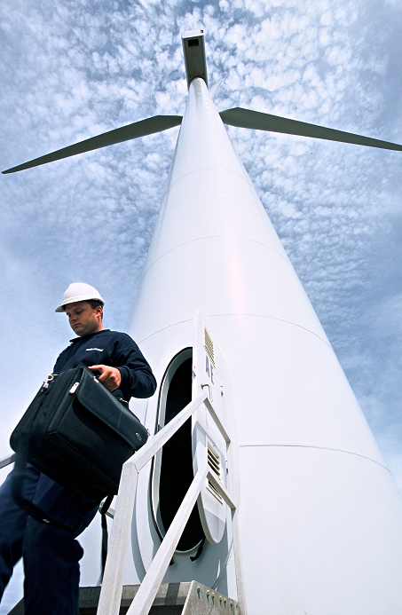 Engineer exiting the base of a wind turbine