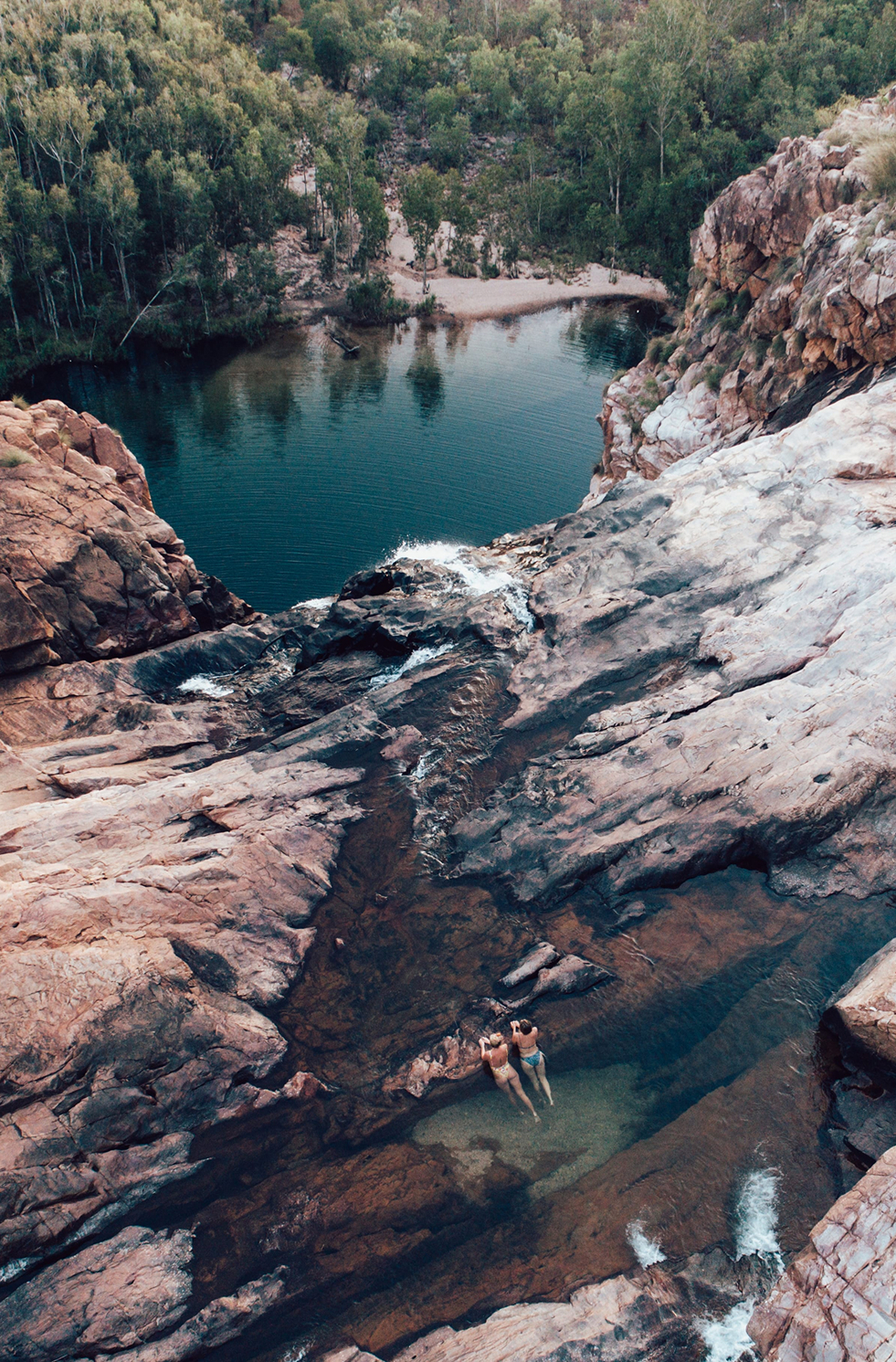 Female swimmer relaxing in a natural rock pool at Gunlom Falls, Kakadu