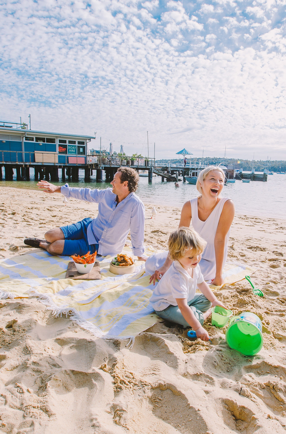 Kid playing in the sand with parent beside him at Balmoral Beach
