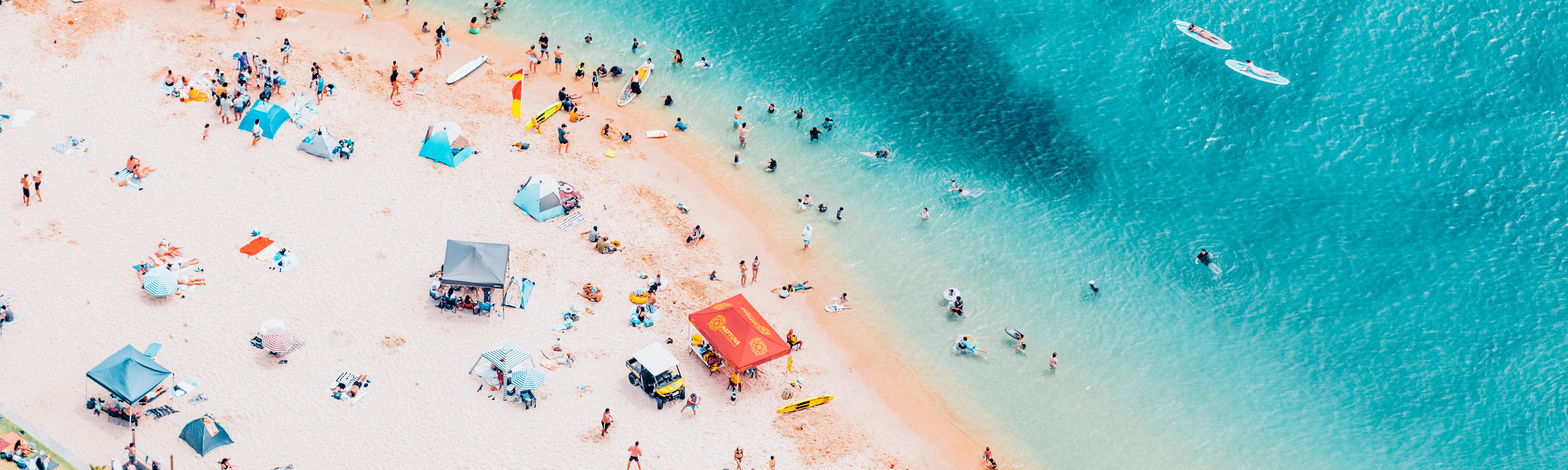 Aerial view of Tallebudgera Creek, Gold Coast, with beachgoers relaxing and swimming in blue water