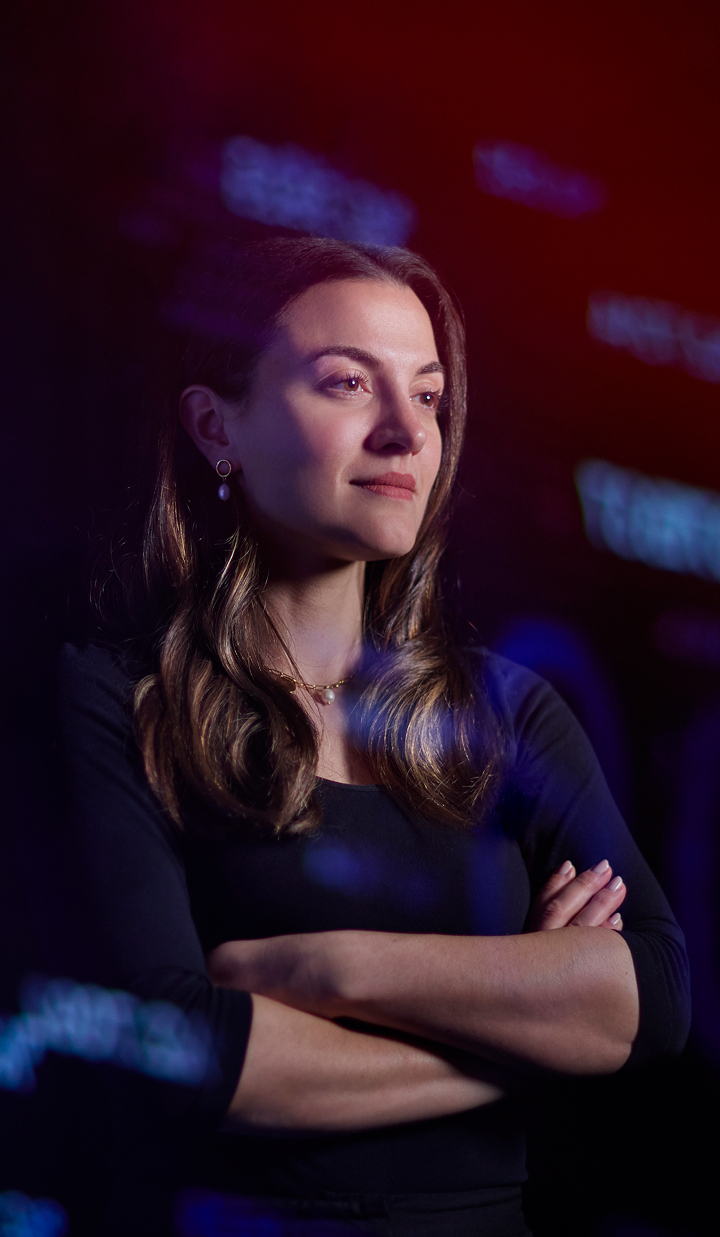Ann Kayis-Kumar standing with arms crossed, looking confident