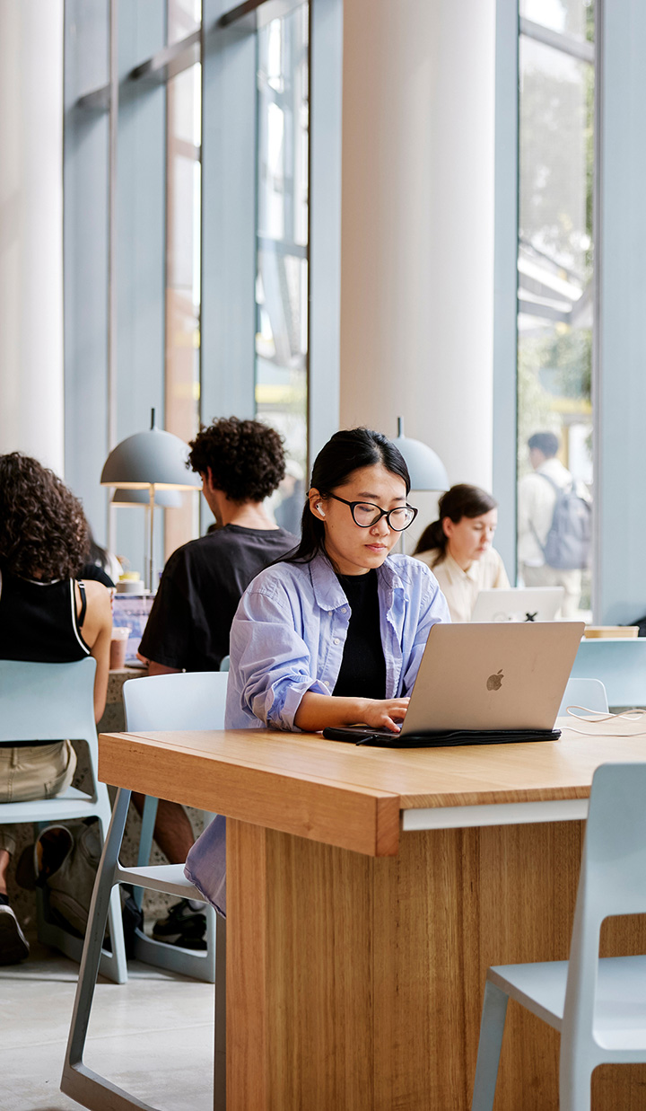 Monash library with an Asian girl studying on her laptop
