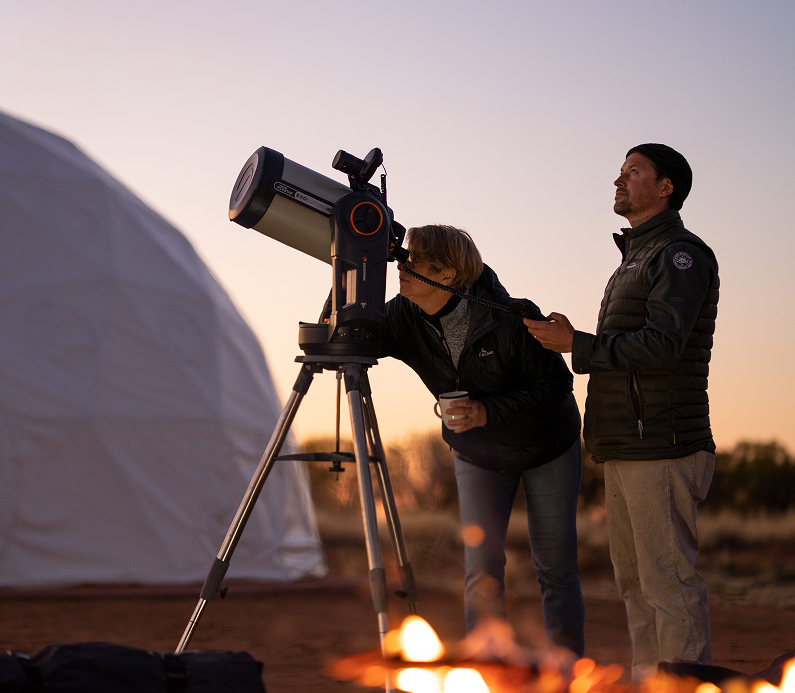 People stargazing under a dark sky overlooking East MacDonnell Ranges.