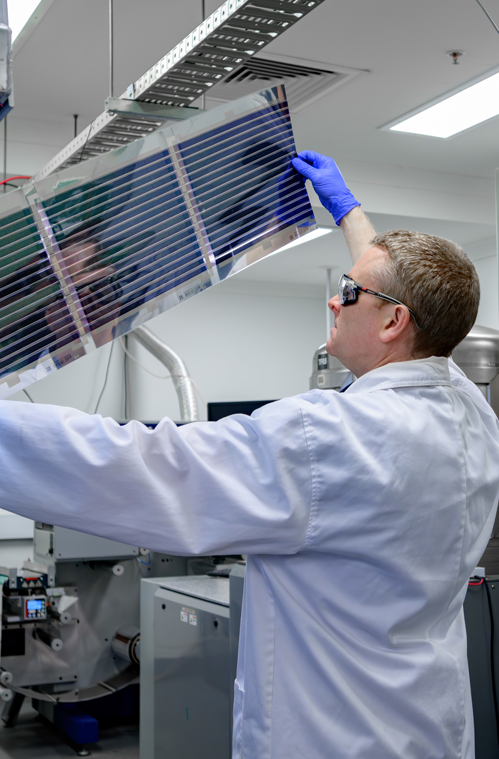 Man printing solar panels in a laboratory setting.