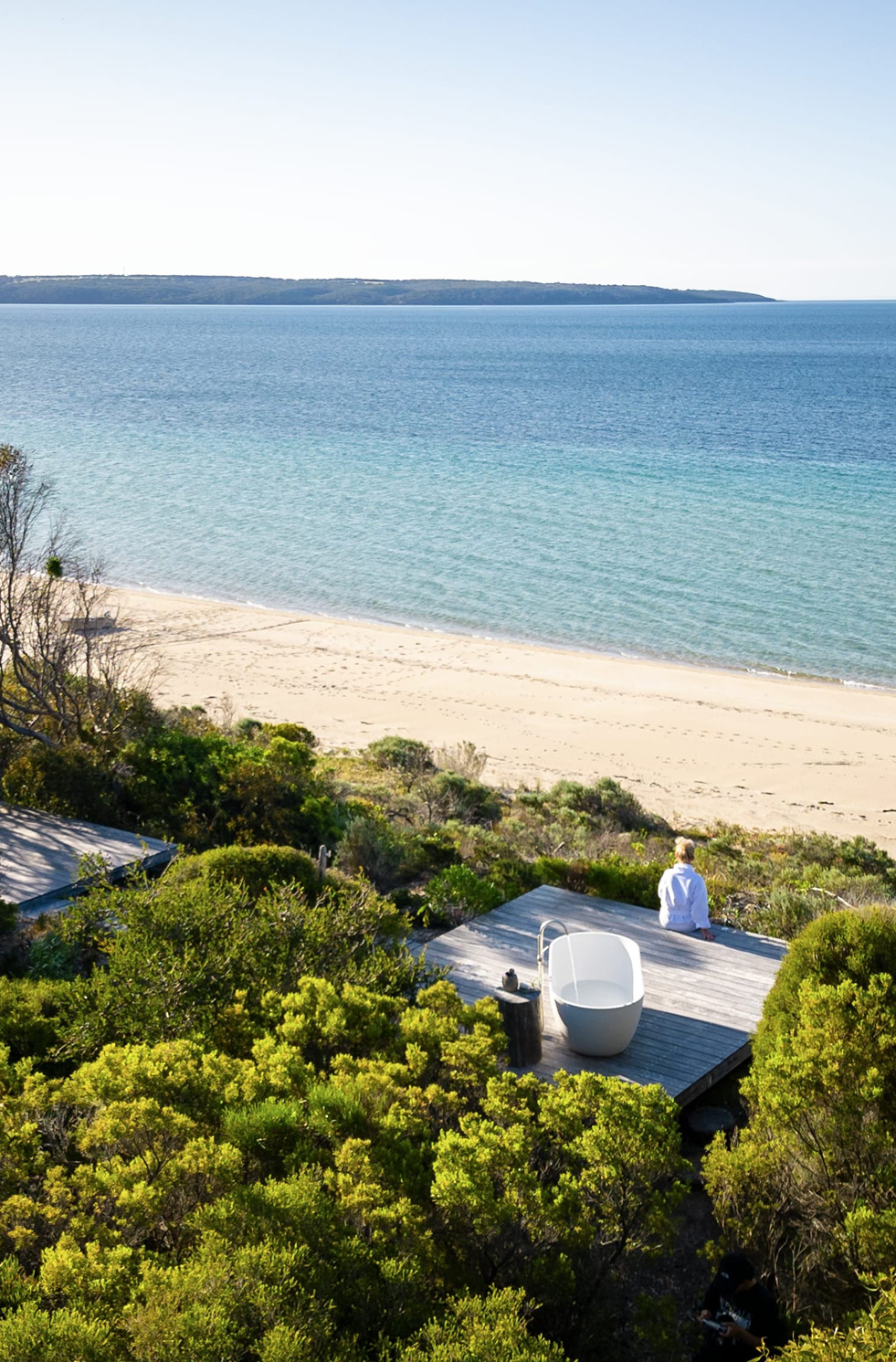 Woman sitting on deck overlooking Brown Beach, Kangaroo Island