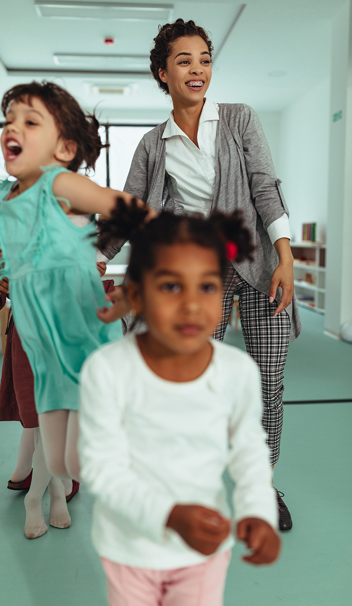 Preschool teacher supervising children playing