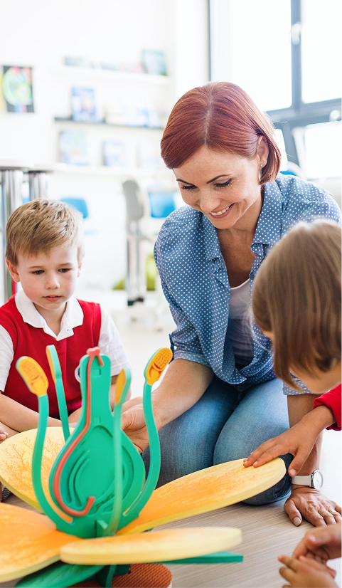 a group of small school children  with teacher sitting