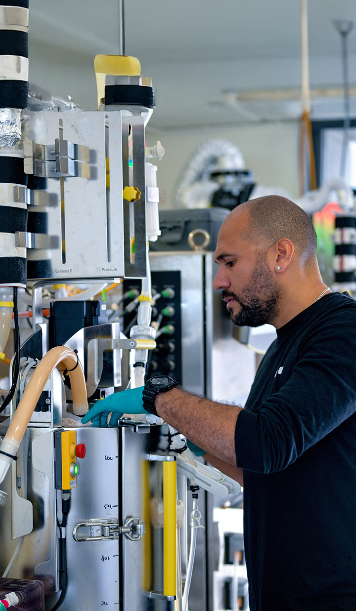 A person inspecting and operating scientific equipment
