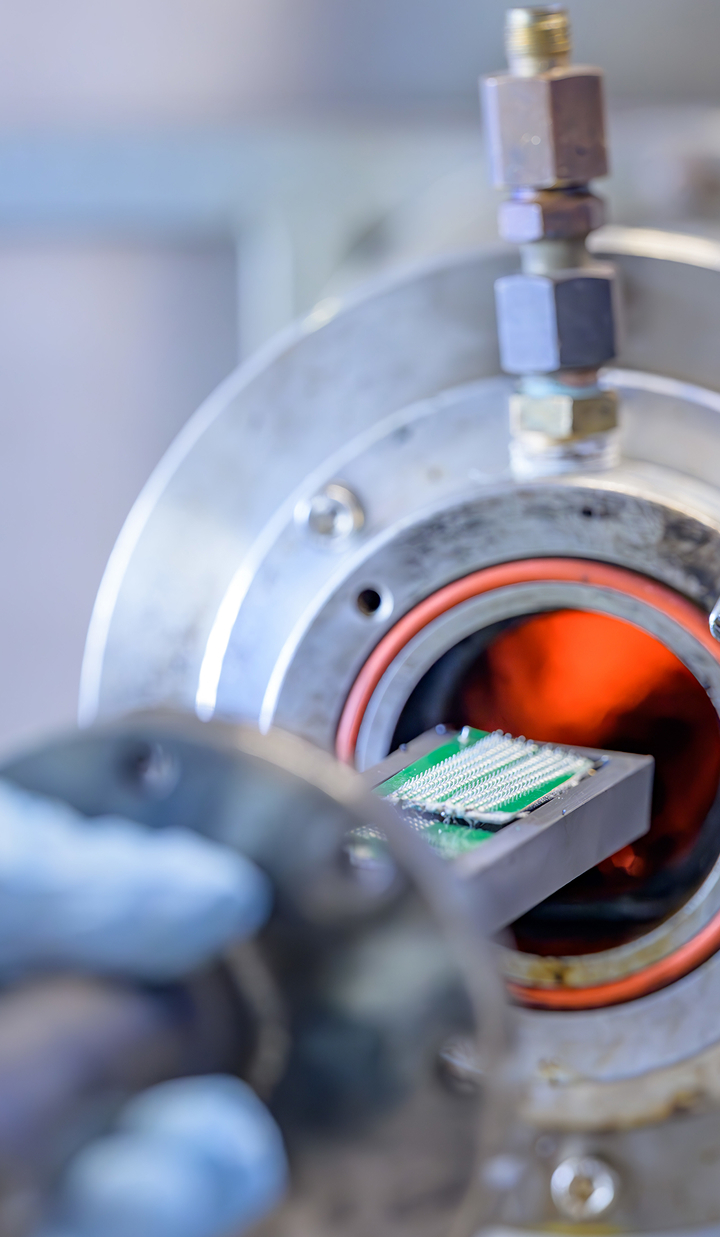 Circuit board being inserted into a high-temperature furnace for e-waste recycling at UNSW SMaRT Centre.