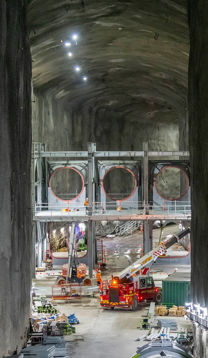 Crane inside a very tall tunnel under construction.