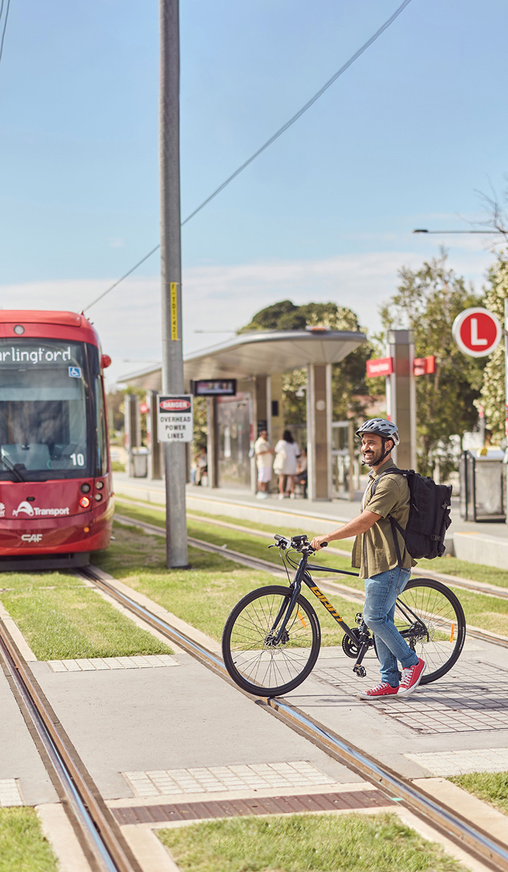 Cyclist crossing the Carlingford light rail station intersection.