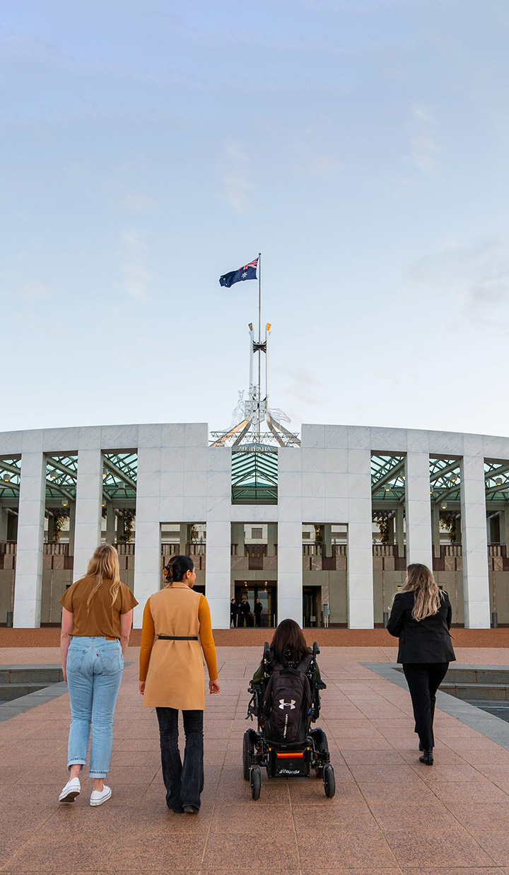 Diverse group of four walking up to Parliament House in Canberra
