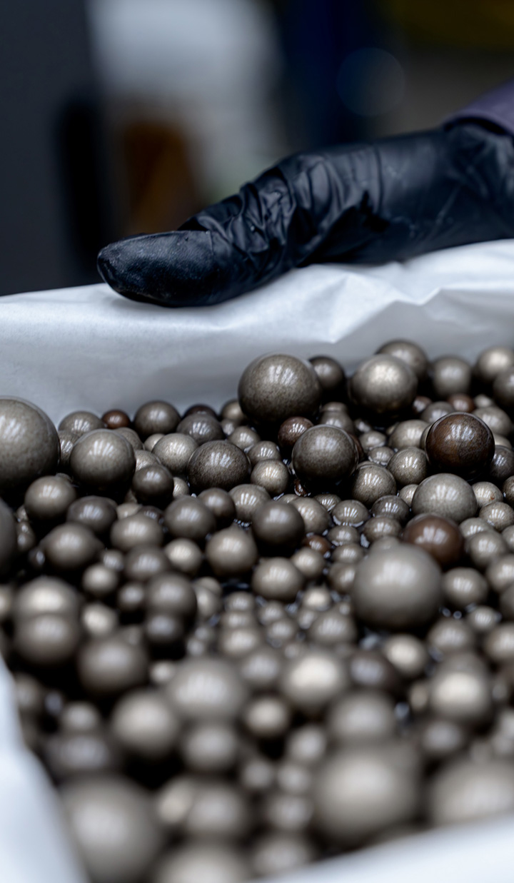 Hand holding a bag with refined mineral marbles