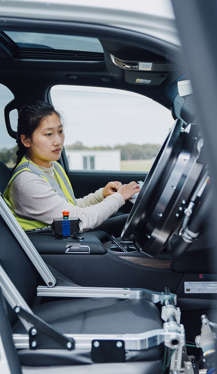 Transport NSW worker checking the systems of an automated vehicle