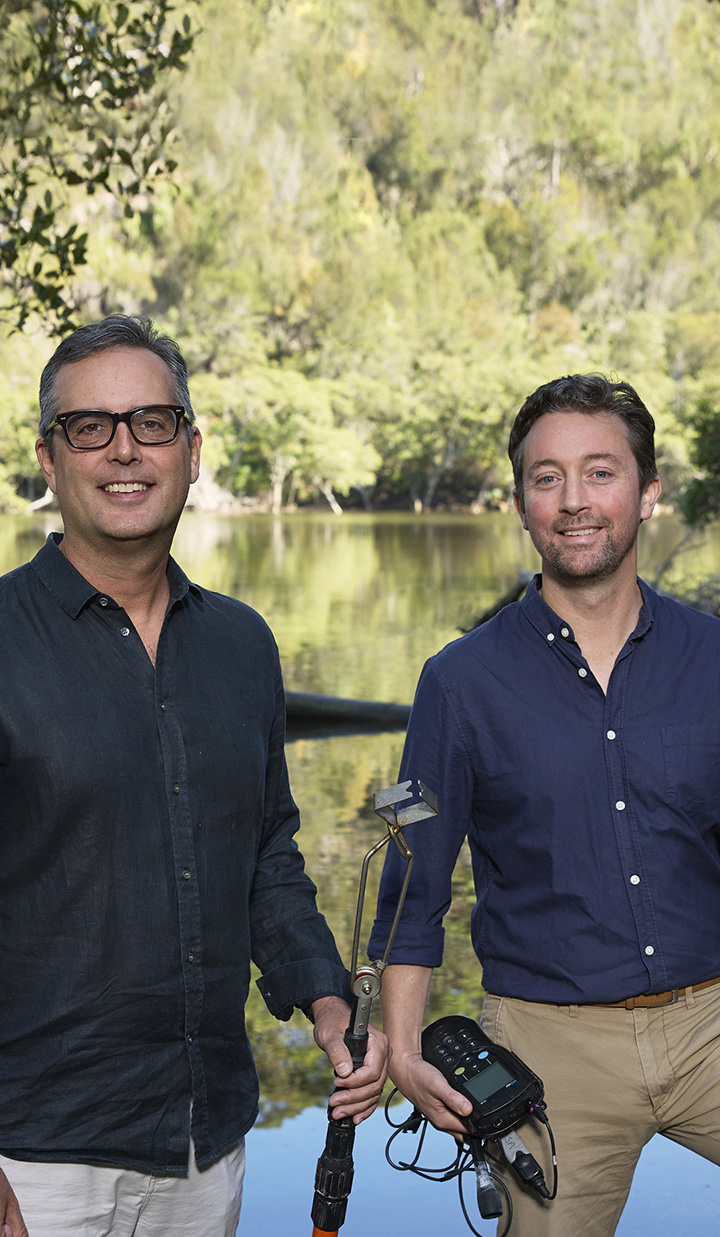 Two men standing in front of a river holding technical equipment. Project Halophyte