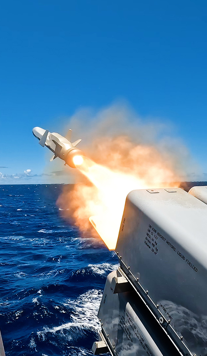Missile launching from ship over the ocean.