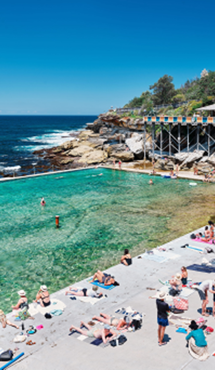 coastal-rock-pool-with-swimmers-and-sunbathers