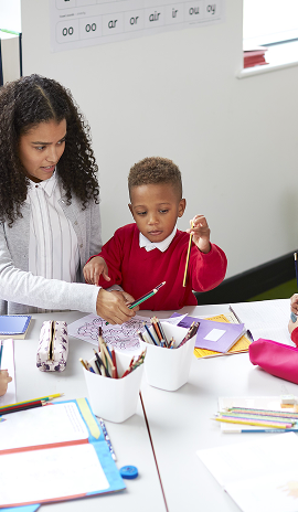 Female early learning kindy teacher sitting with children.png