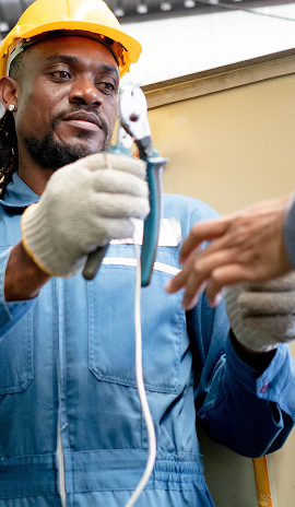 Electrical tradesperson using pliers while wearing safety gear