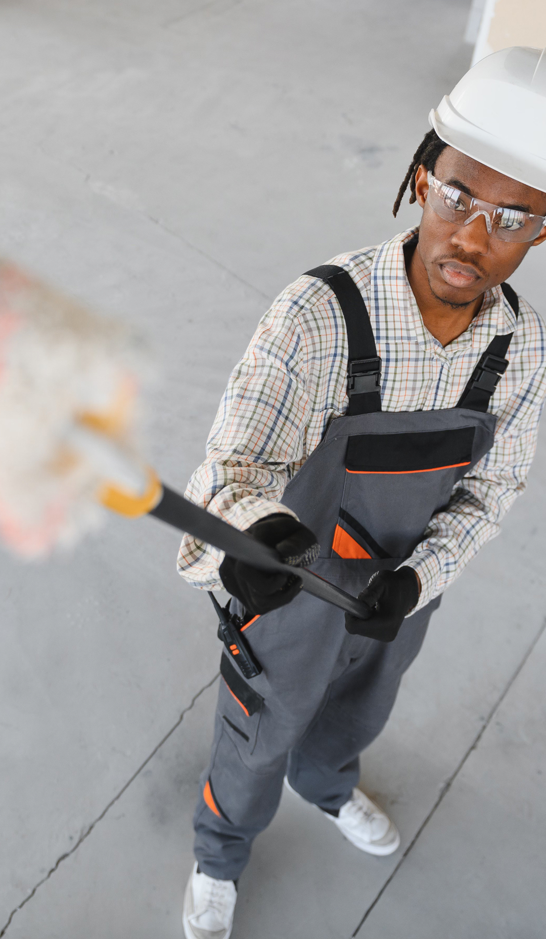 Painter wearing safety gear working with tools at an industrial site