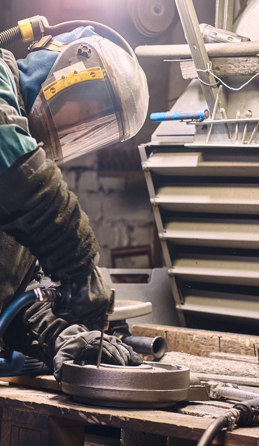 Industrial worker operating machinery while wearing protective equipment