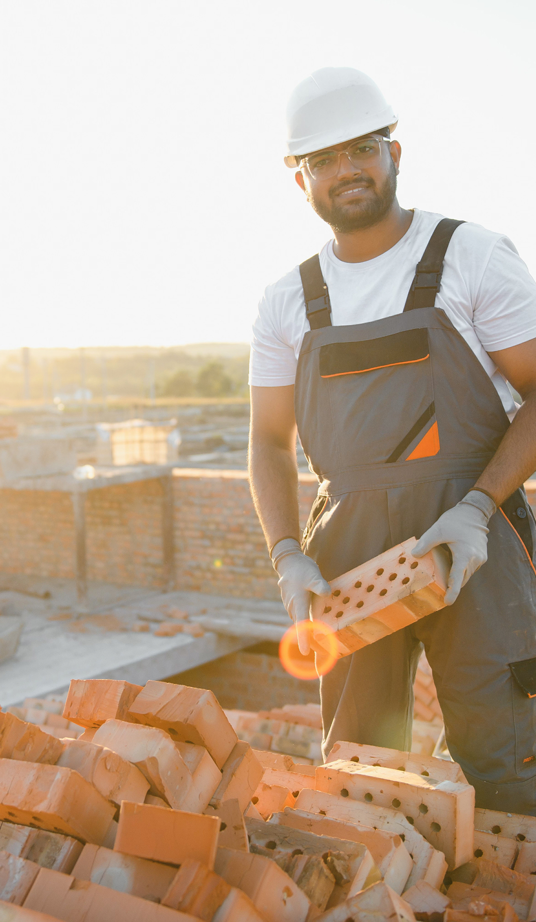 Construction worker holding bricks at a building site during daylight