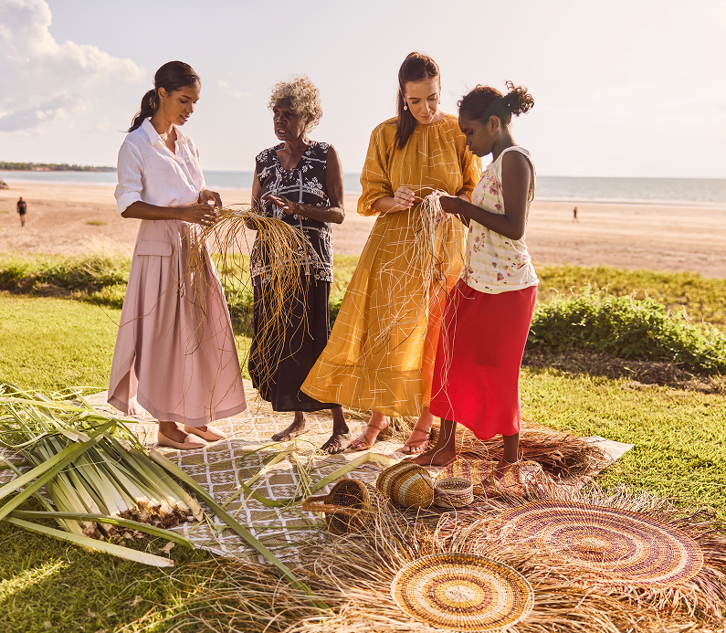 Indigenous guide demonstrates traditional weaving techniques at sunset