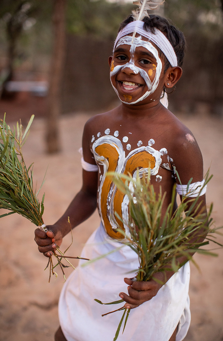Indigenous boy wearing traditional face paint preparing for a cultural dance