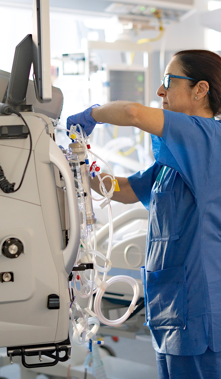 nurse setting up a hemofiltration machine in the icu