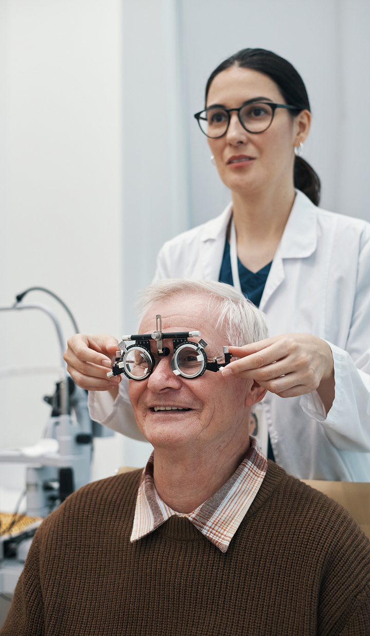 senior man undergoing eye exam with female optometrist.