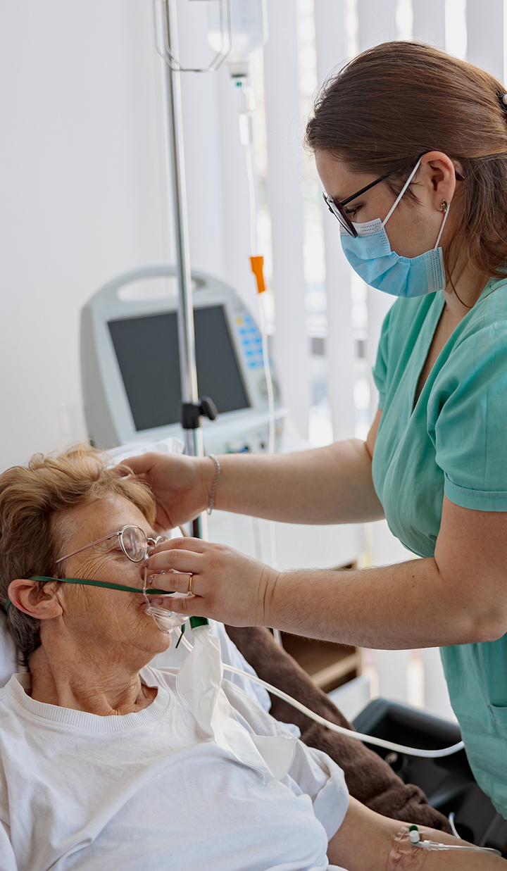 nurse putting on a breathing mask on a female patient
