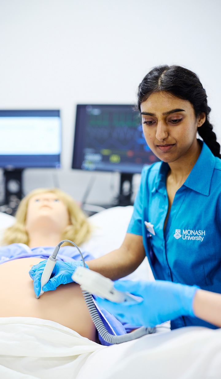 nursing student performing ultrasound on pregnancy mannequin in simulation lab