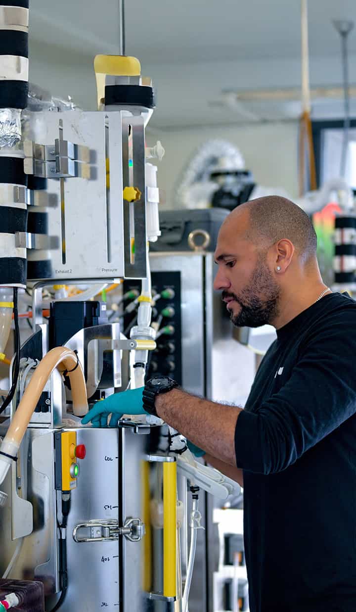 A person inspecting and operating scientific equipment