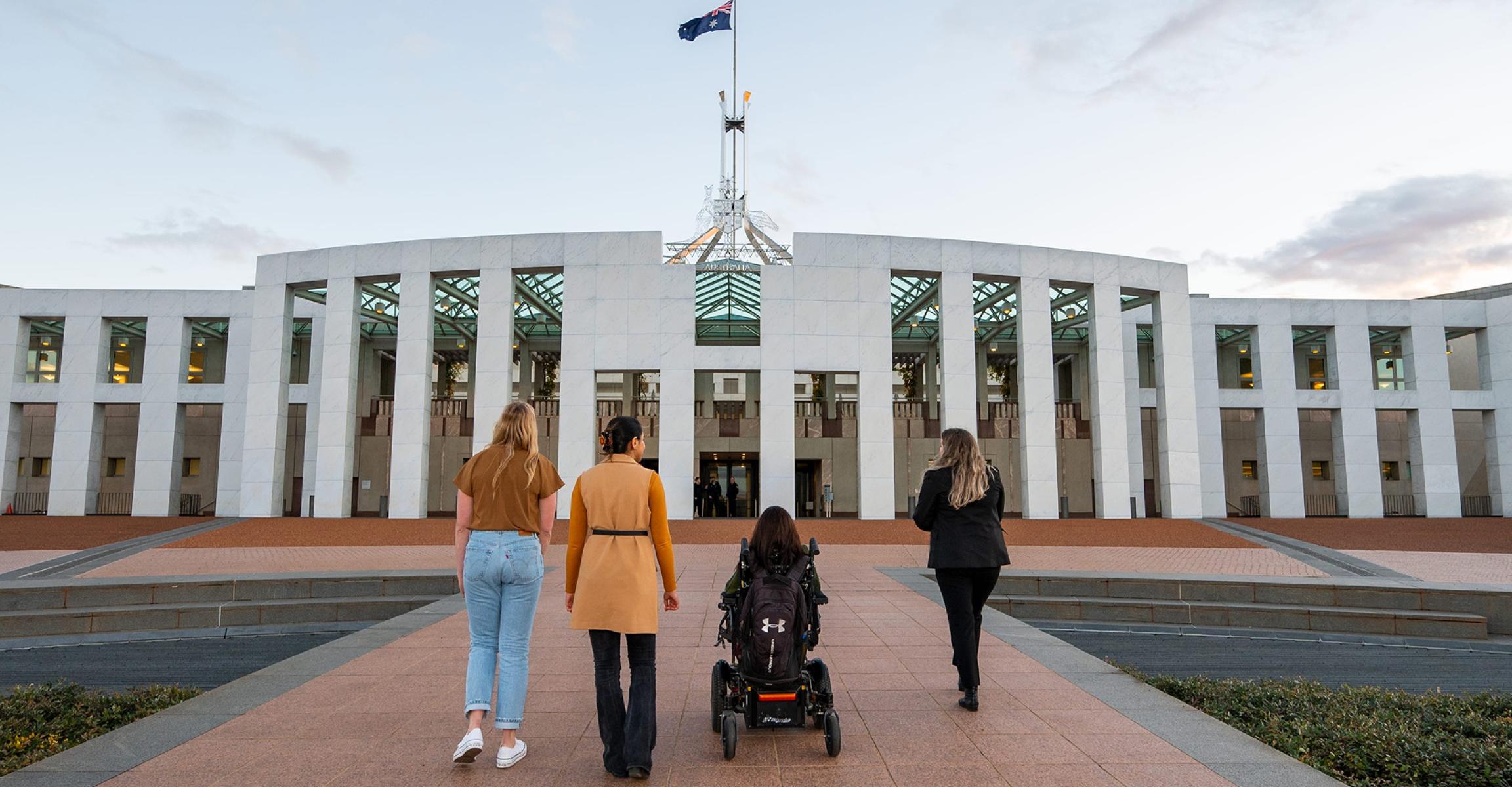 Diverse group of four walking up to Parliament House in Canberra