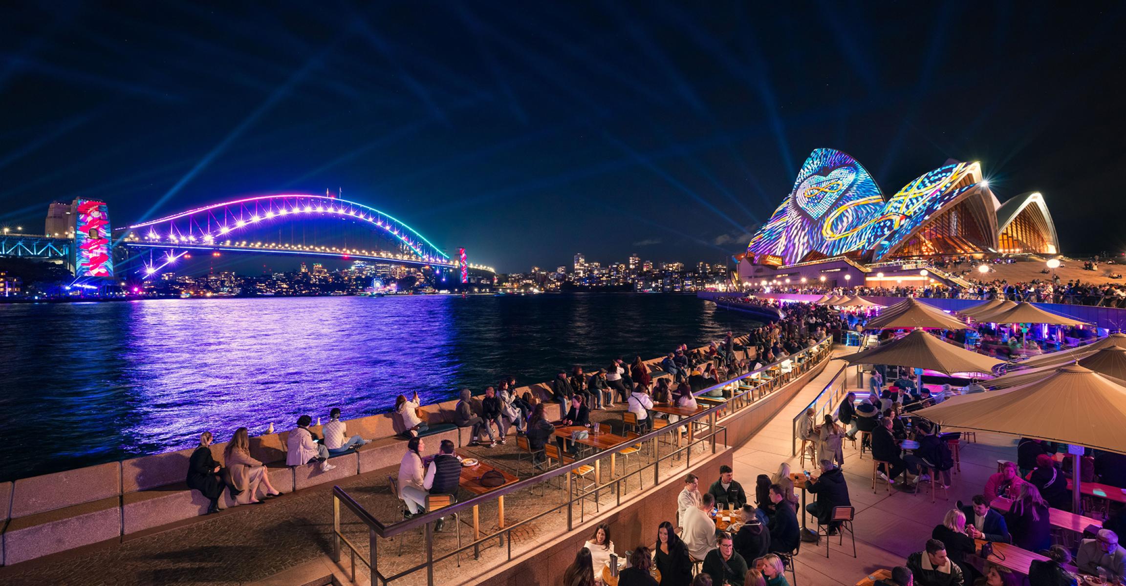 Vivid festival lights illuminating the Sydney Opera House and Sydney Harbour Bridge.
