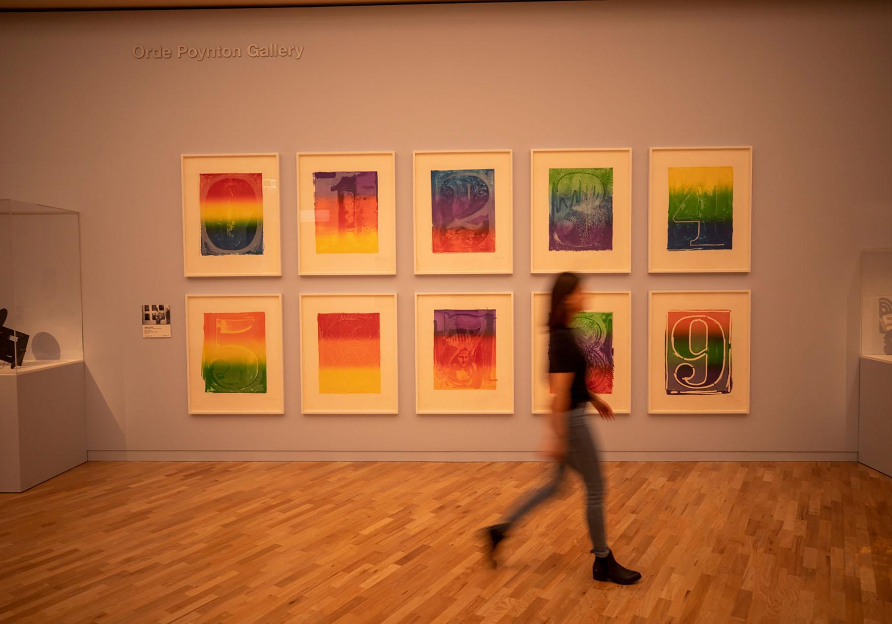woman walking past modern artwork in an art gallery